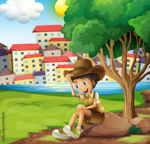 A young explorer sitting above the rock across the tall building