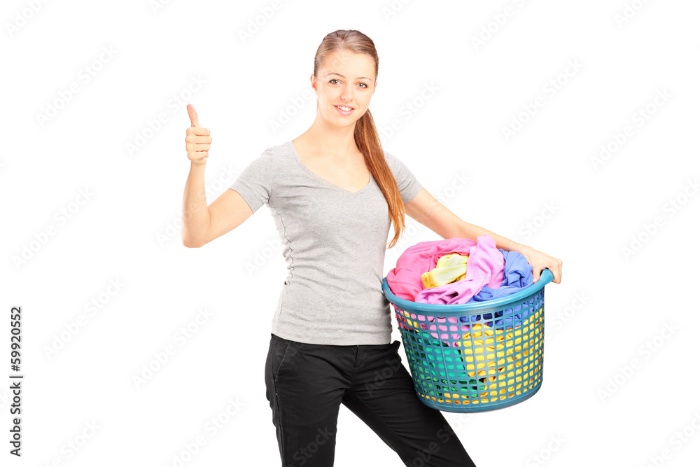 Young woman with laundry basket full of clothes giving thumb up Young woman with laundry basket full of clothes giving thumb up