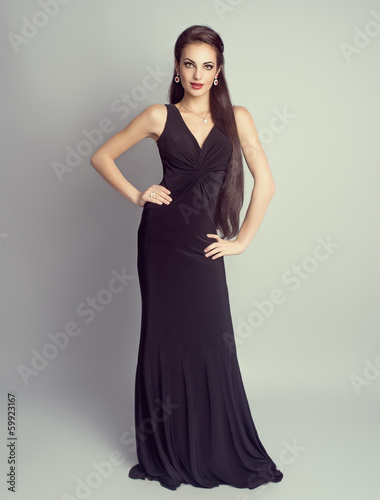 Rich brunette girl in luxury evening black dress in studio