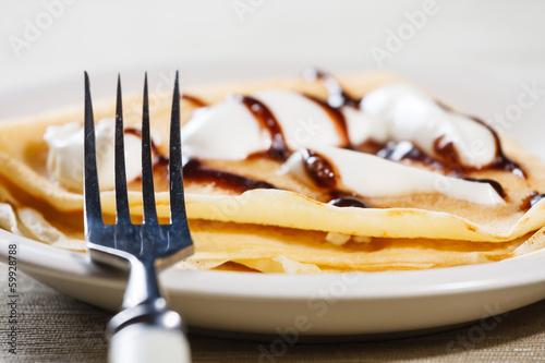 Close up of French style crepe with cream and chocolate sauce photo