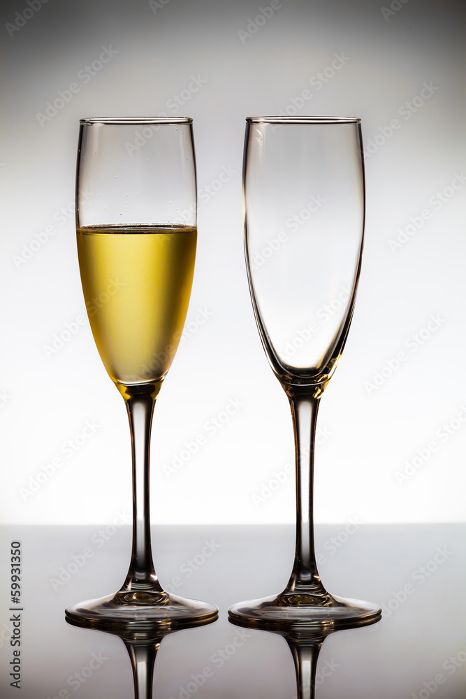 empty glasses of champagne and one being filled 