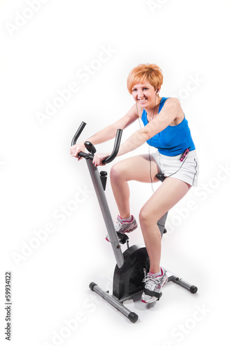Woman doing sports on exercise bike