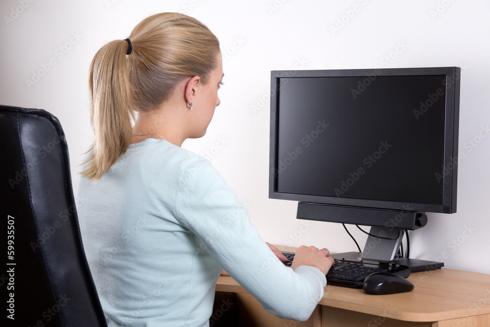 back view of woman with personal computer in office back view of woman with personal computer in office