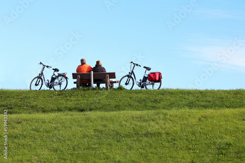 Slika na platnu Pair with bikes made a rest on the dam
