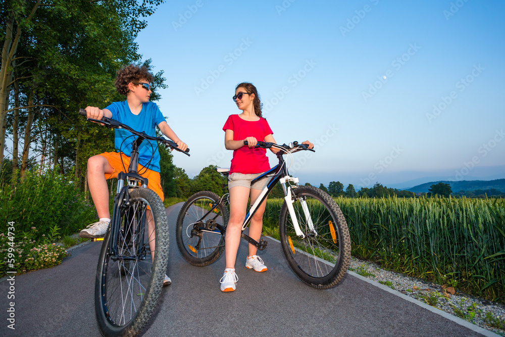 Fototapeta premium Healthy lifestyle - teenage girl and boy biking