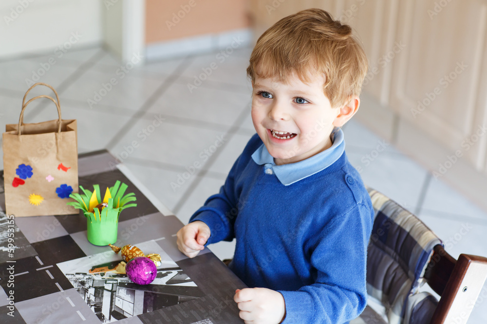 Little toddler boy being happy about selfmade Easter egg in kind