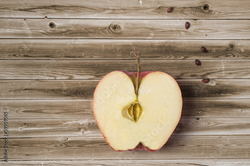 Apple with seeds on wooden surface