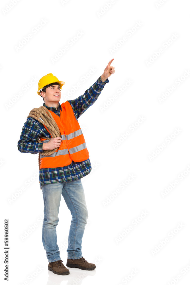 Construction worker holding rope and pointing up. Construction worker holding rope and pointing up.