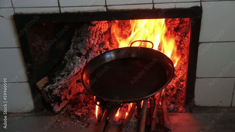 Echando aceite en una paella al fuego