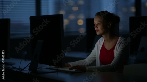 Young female student working alone in a computer classroom