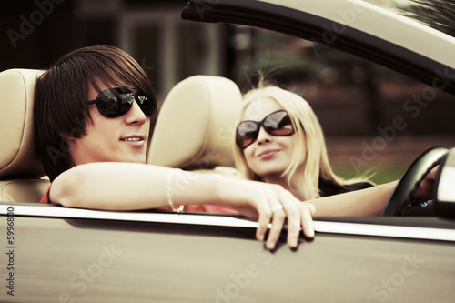 Happy young couple driving a convertible car © Wrangler