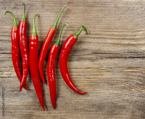 Red hot chili peppers on old wooden table