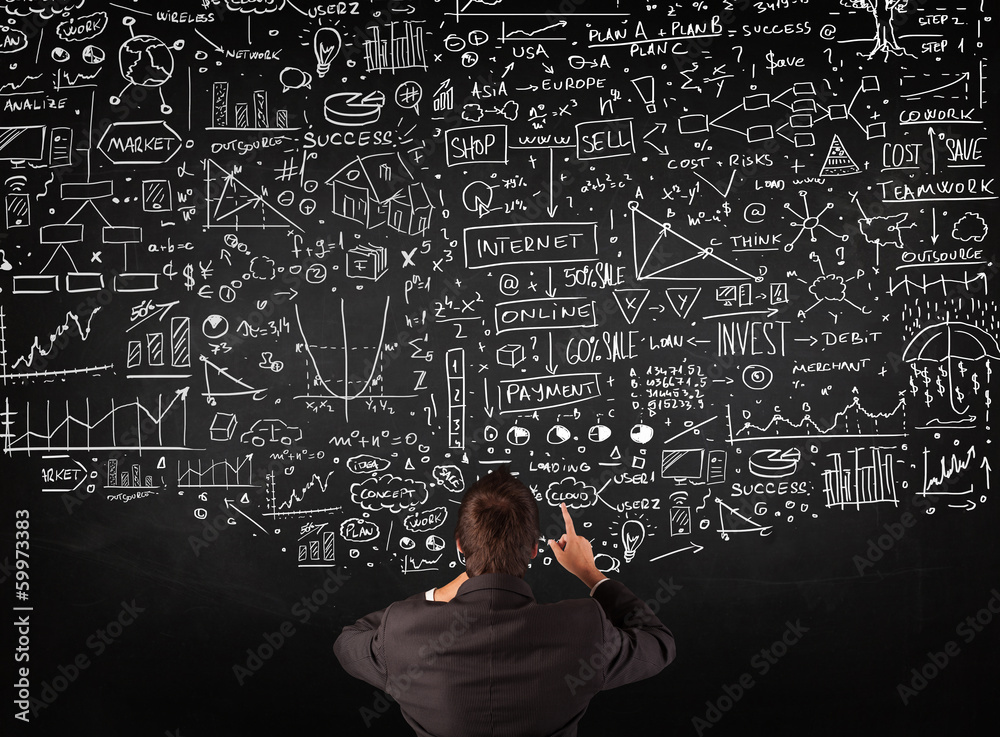 Businessman standing in front of drawn charts on a blackboard Businessman standing in front of drawn charts on a blackboard