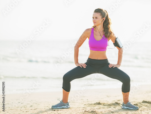 Fitness young woman making exercise on beach