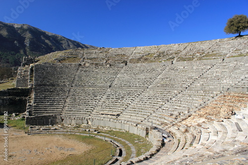 Ancient archaeological site amphitheater or amphitheatre in Dodoni in Greece with stone seats and steps