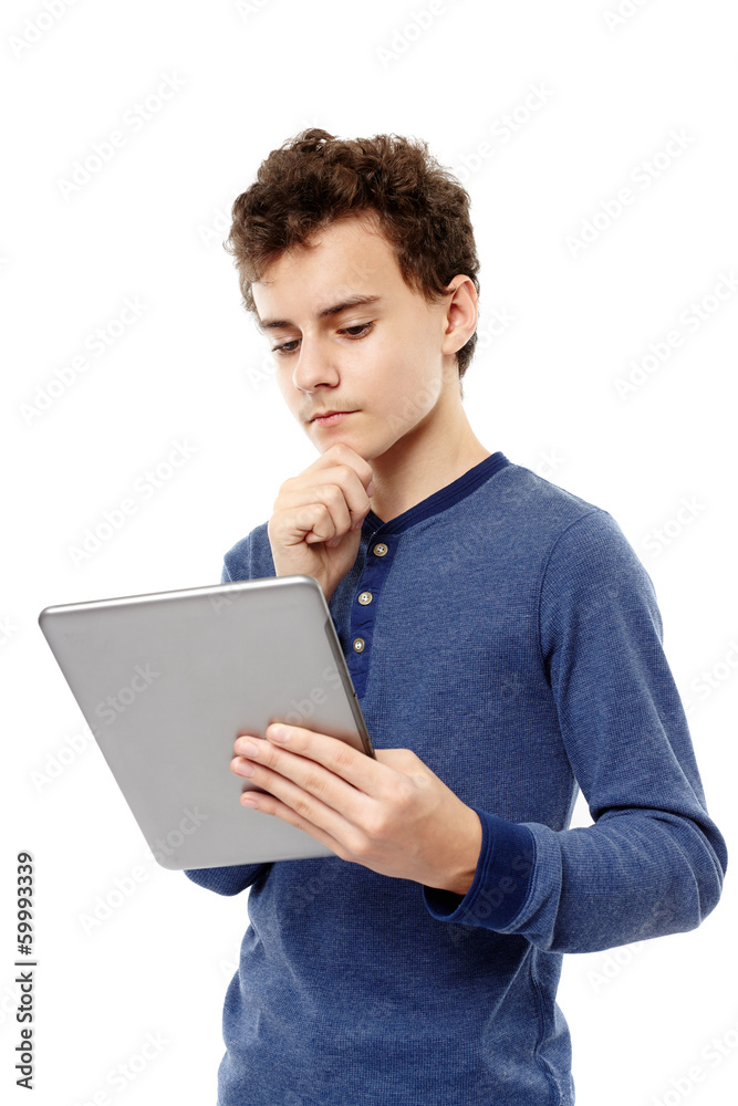Smart teenager working on a tablet he is holding with hand on ch Smart teenager working on a tablet he is holding with hand on ch