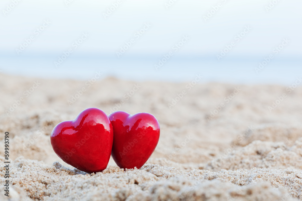 Two red hearts on the beach symbolizing love, Valentine's Day Two red hearts on the beach symbolizing love, Valentine's Day