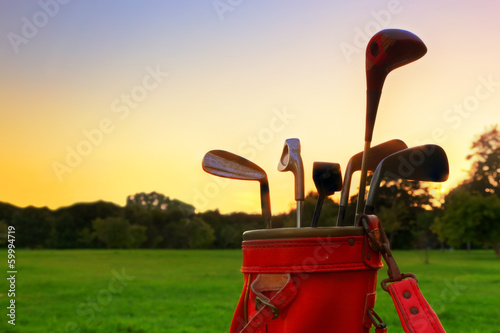 Golf equipment. Professional golf clubs at sunset