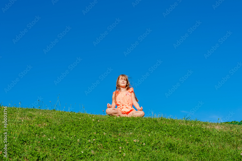 Beautiful little girl meditating outdoors Beautiful little girl meditating outdoors