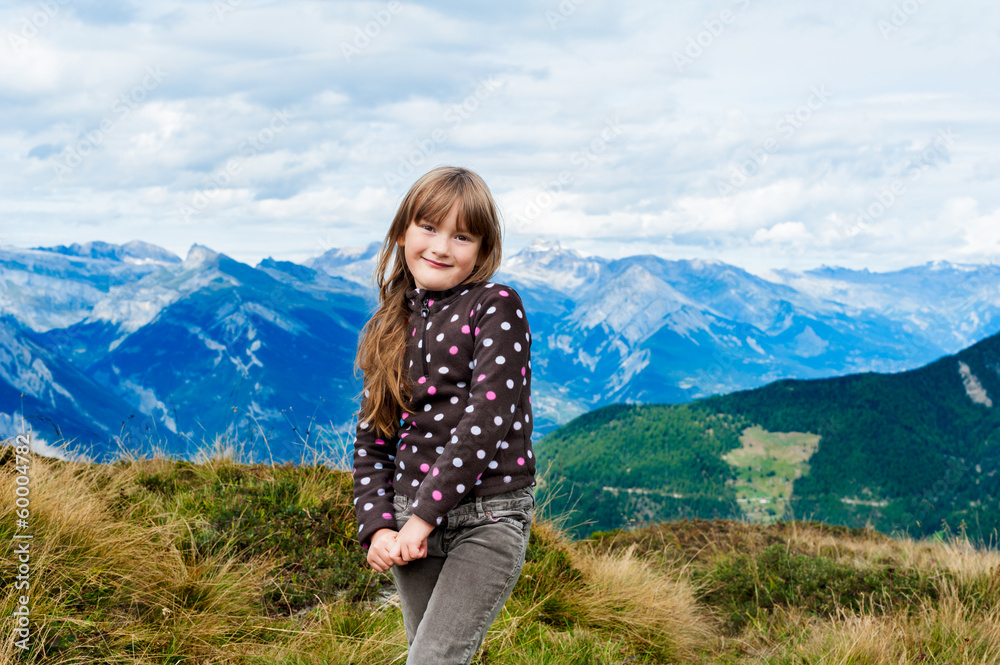 portrait of little girl with mountains on background