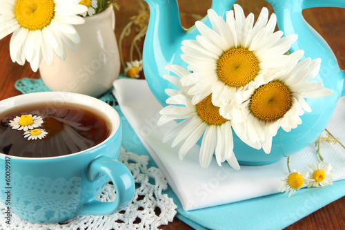 Fototapeta Naklejka Na Ścianę i Meble -  Beautiful bouquet chamomiles in teapot on wooden table close-up