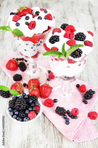 Natural yogurt with fresh berries on wooden background