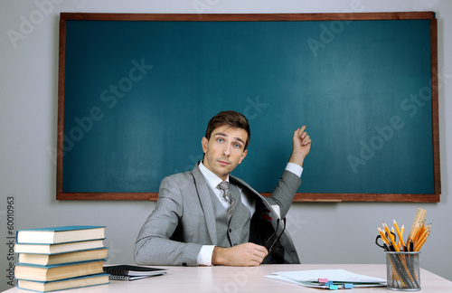 Young teacher sitting in sc...