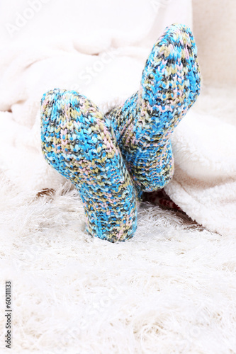Female legs in colorful socks on white carpet background