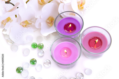 Beautiful colorful candles and orchid flowers, isolated on