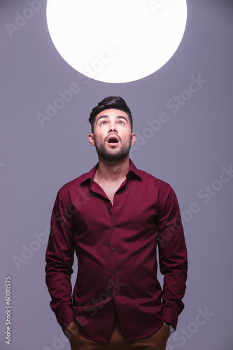 amazed casual man looking into a sphere of light
