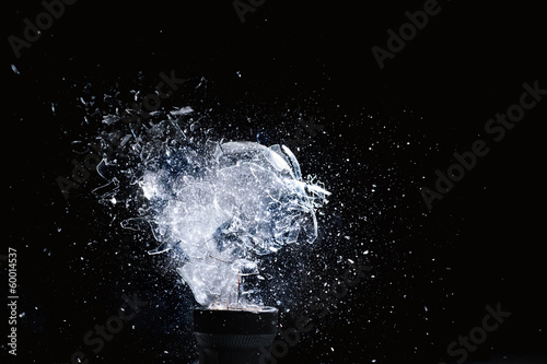 Traditional tungsten filament bulb bulbs are hit by a bullet and explode. high speed photography. black background nobody around.