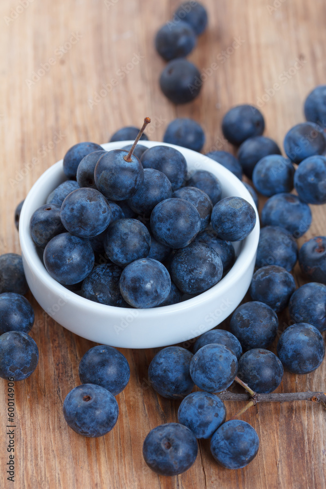 Blackthorn berry (sloe) in a bowl on wooden table Blackthorn berry (sloe) in a bowl on wooden table