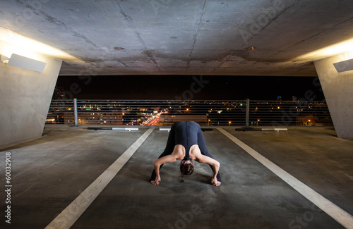 Young Woman holding yoga poses in a public space photo