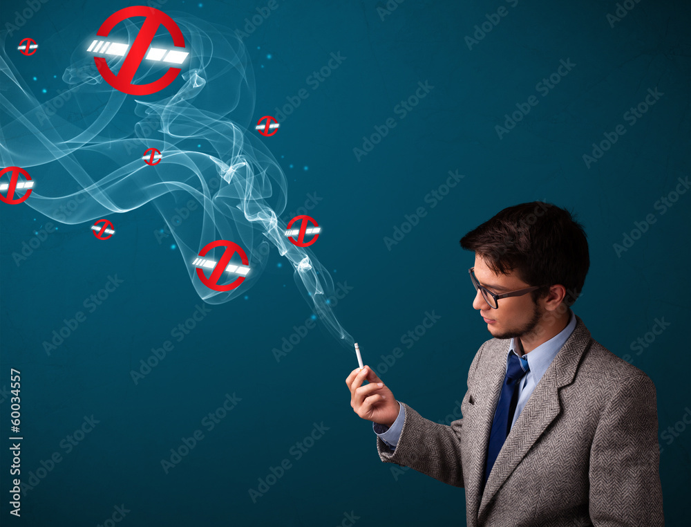 Attractive man smoking dangerous cigarette with no smoking signs Attractive man smoking dangerous cigarette with no smoking signs