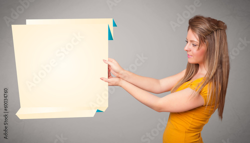 Young woman holding white origami paper copy space