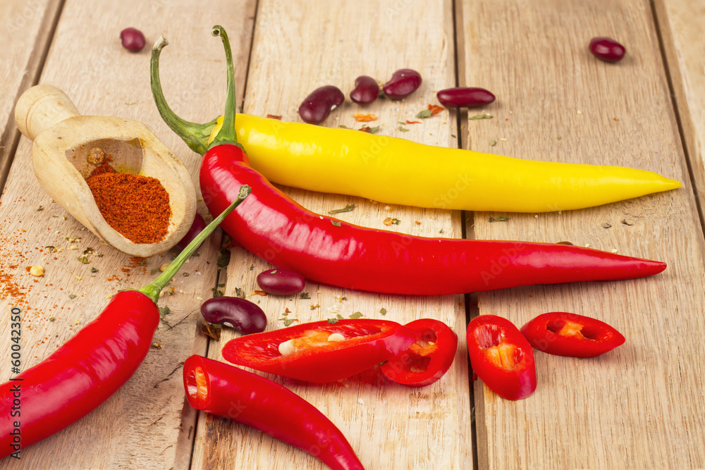 Red and yellow chili peppers on wooden background