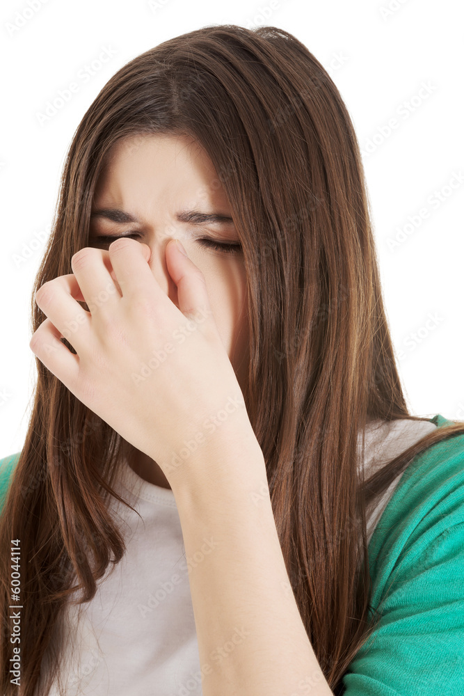 Young beautiful woman with sinus pressure, touching her nose. Young beautiful woman with sinus pressure, touching her nose.