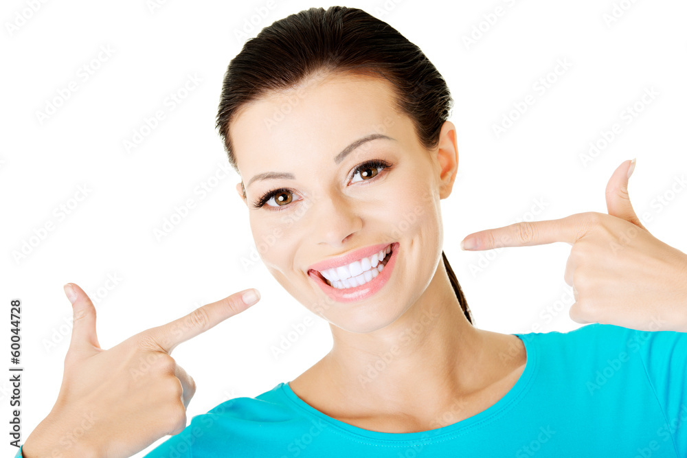 Beautiful woman teeth. Girl pointing on her perfect white smile. Beautiful woman teeth. Girl pointing on her perfect white smile.