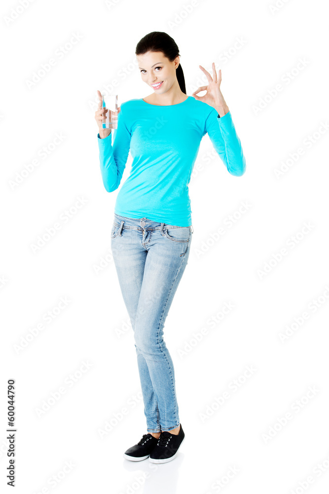 Young casual woman with glass of water. Young casual woman with glass of water.