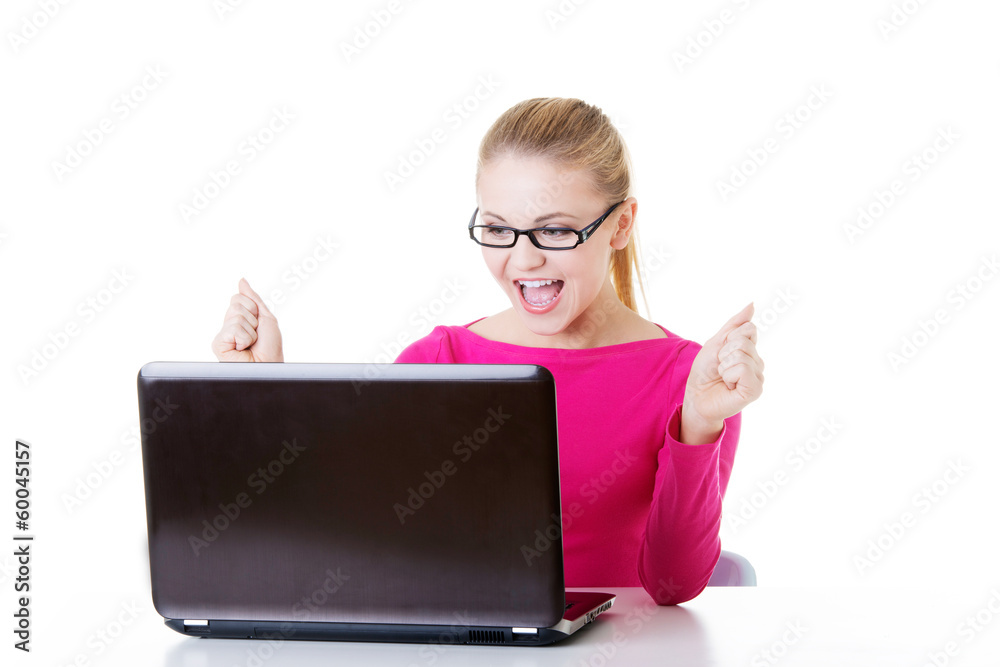 Young happy woman sitting in front of laptop. Young happy woman sitting in front of laptop.