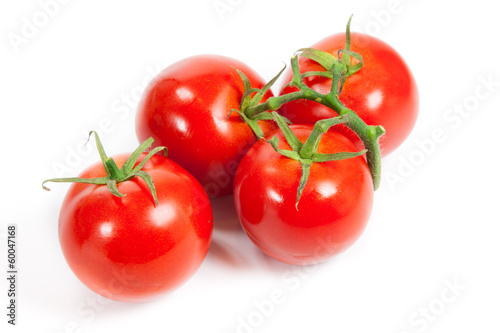 three fresh tomatoes with green leaves isolated on white backgro