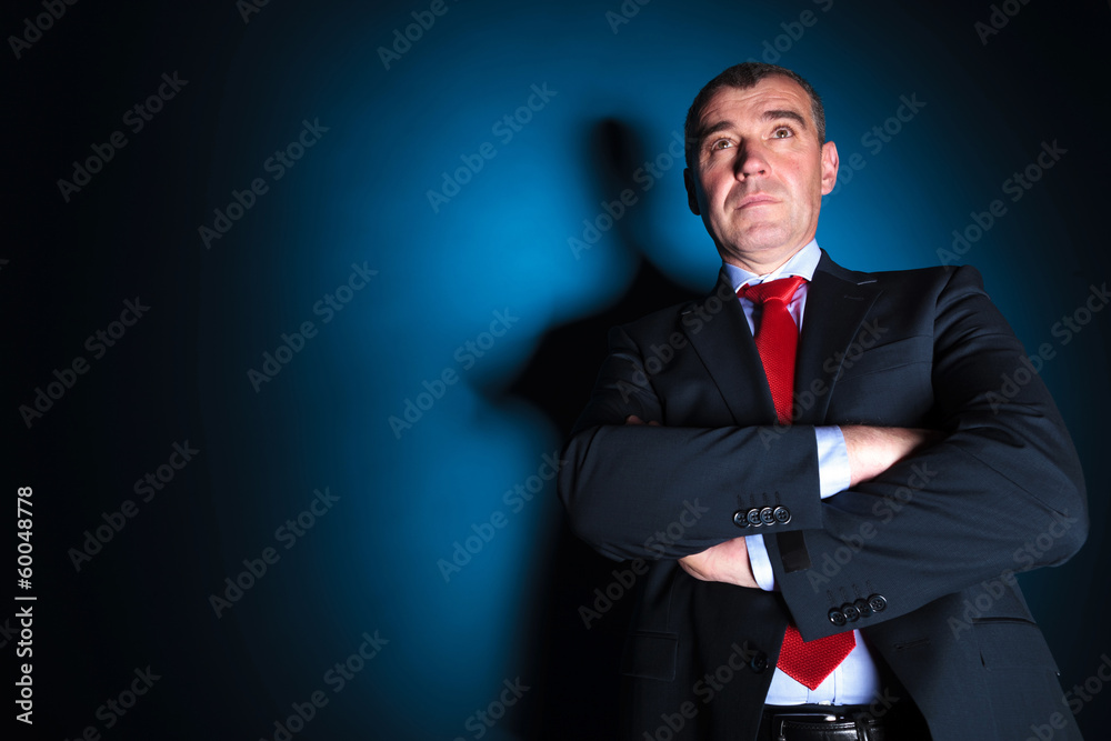 serious old business man with arms folded looking away