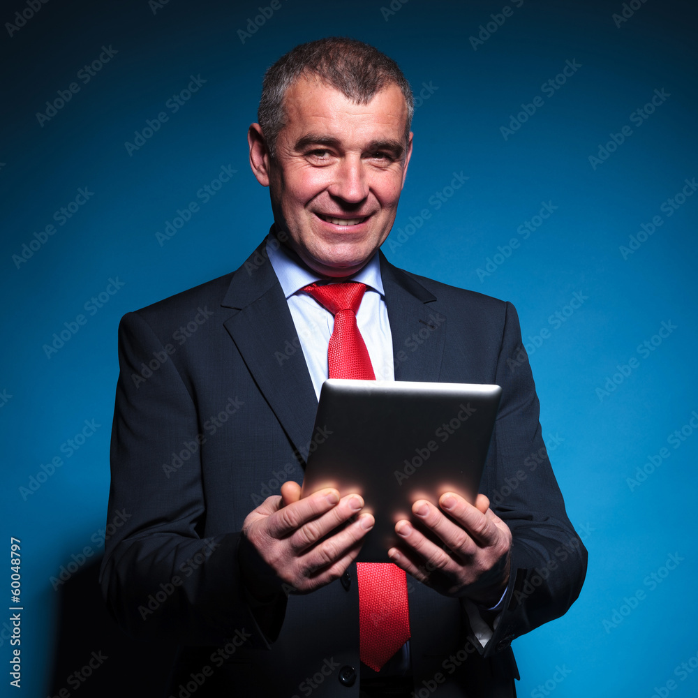 business man holding a tablet pad and smiles business man holding a tablet pad and smiles