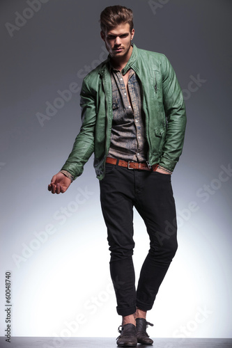 young casual man in leather jacket posing