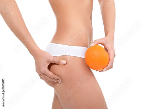 Young woman in underwear with an orange showing absence of cellu