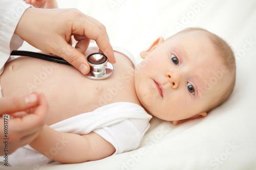  pediatrician visits a very young Caucasian child with a stethoscope. concept of childcare and health.