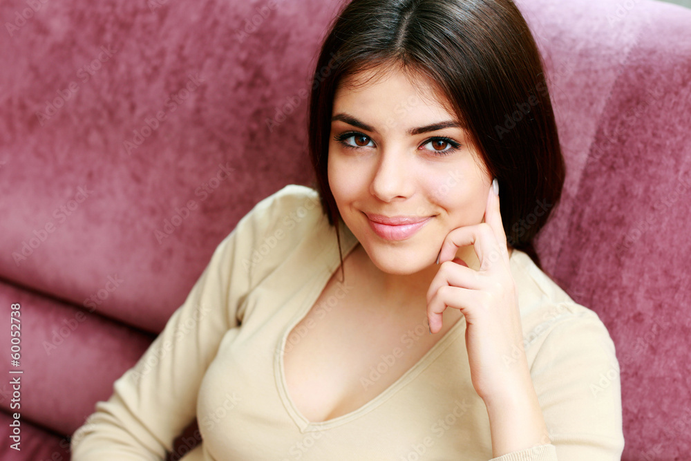 cheerful woman sitting on the sofa at home cheerful woman sitting on the sofa at home