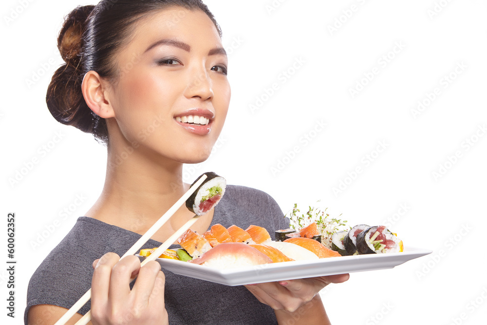Woman holding sushi with chopsticks looking at the camera smilin Woman holding sushi with chopsticks looking at the camera smilin