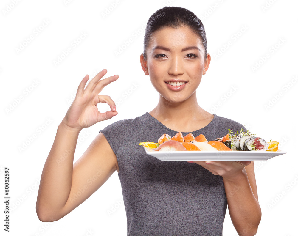 Woman holding sushi with chopsticks looking at the camera smilin Woman holding sushi with chopsticks looking at the camera smilin