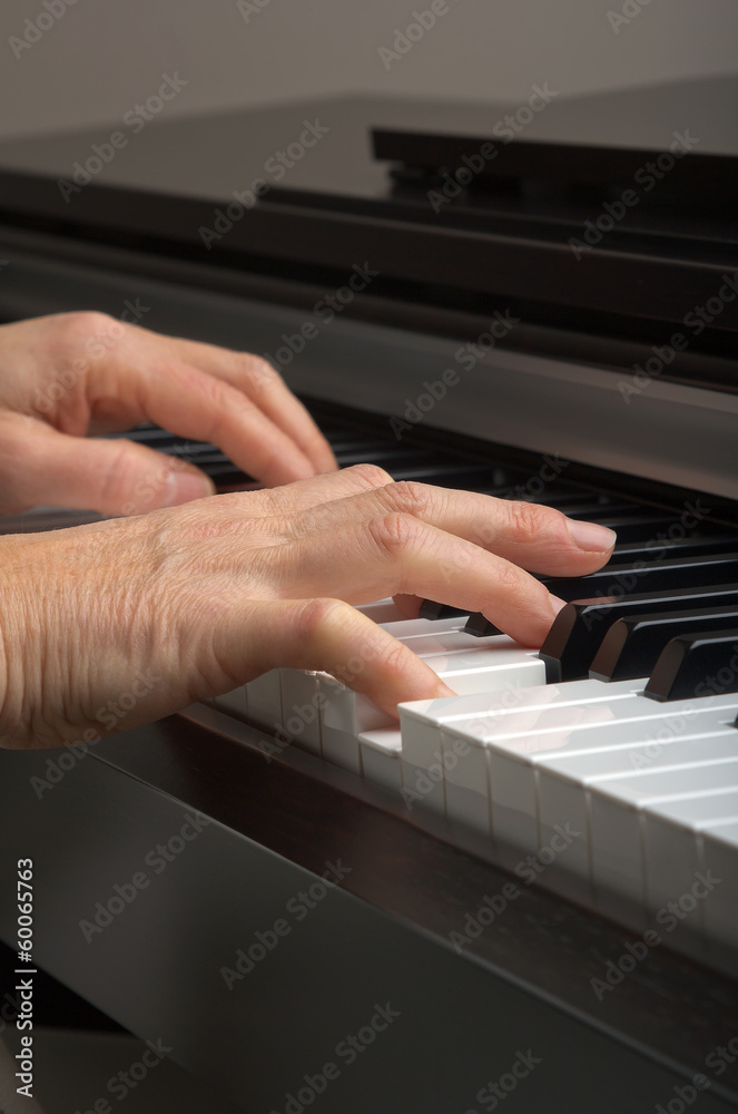 Fototapeta premium Two hands playing on the piano